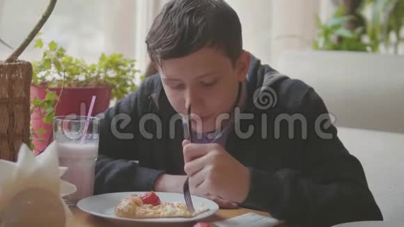 少年在咖啡厅慢动作视频里吃披萨他正在吃美味的披萨朋友在一家公司吃饭视频的预览图