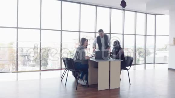 年轻员工坐在办公室的桌子上用笔记本电脑团队工作头脑风暴会议的概念视频的预览图