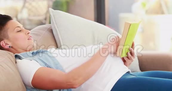 孕妇躺在沙发上看书视频的预览图
