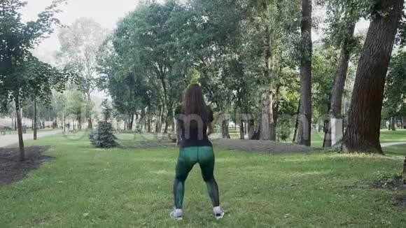 美丽的黑发女人在公园里做早操视频的预览图