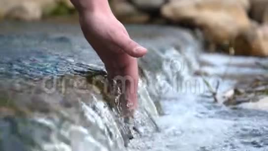 有人用手在泉源的水中洗手把水清净视频的预览图