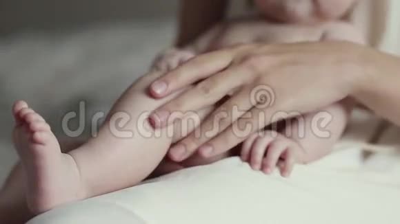 年轻的另一只手轻轻抚摸着婴儿的皮肤视频的预览图