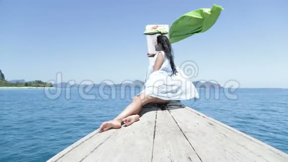 美丽的女人坐在泰国的船鼻子在海后景下年轻的女孩视频的预览图