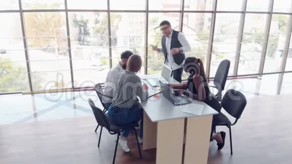 年轻员工坐在办公室的桌子上用笔记本电脑团队工作头脑风暴会议的概念视频的预览图