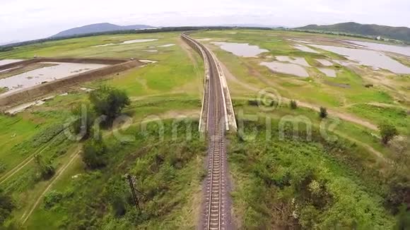 泰国一座山林和水资源旁边的大坝上的空中观景火车过桥视频的预览图