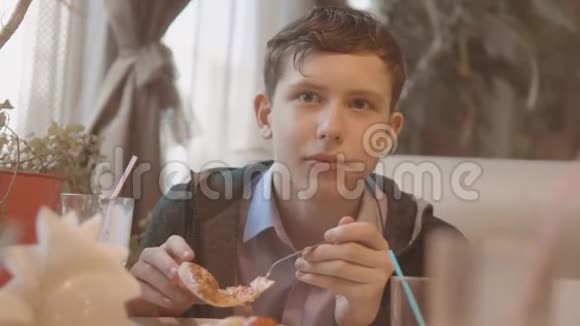 少年在咖啡厅慢动作视频里吃披萨他正在吃美味的披萨朋友在一家公司吃饭视频的预览图