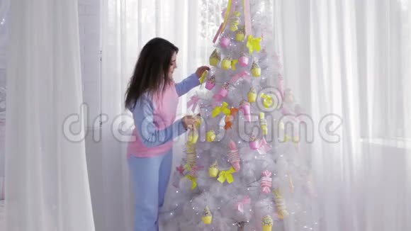 女孩用玩具装饰圣诞树视频的预览图