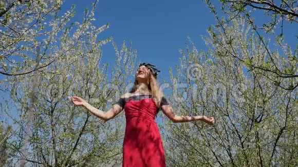 站在春暖花开的花园里穿着长裙的年轻美女视频的预览图