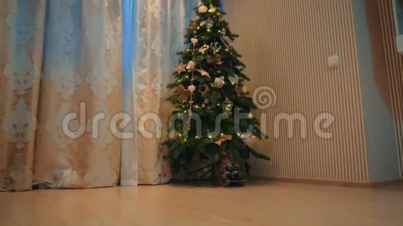 美丽的金发女孩在舒适的晚屋里装扮一棵圣诞树视频的预览图
