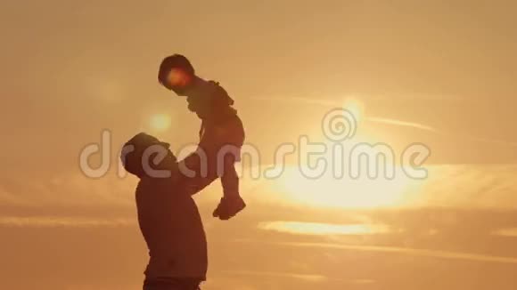 父亲和儿子的剪影在日落海滩上嬉戏视频的预览图