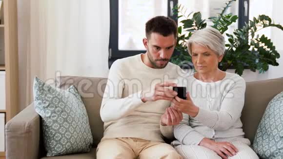 有智能手机的老母亲和成年儿子视频的预览图
