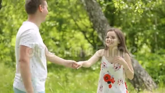 春季或夏季在绿茵场上玩耍的年轻夫妇总计划视频的预览图