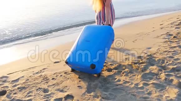 很有魅力的年轻女人带着手提箱在海滩上视频的预览图