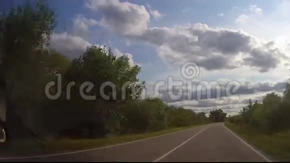日落时的沥青路与模糊汽车卡车开着柏油路在乡村度过美好的春日视频的预览图