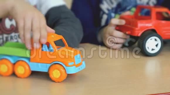 孩子们在桌旁玩玩具模型车视频的预览图