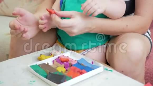 漂亮的小男孩和他的母亲在家里雕刻粘土一起玩和制作动物雕像儿童视频的预览图
