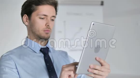 在办公室使用平板电脑的年轻商人视频的预览图