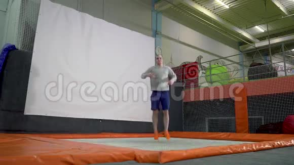 年轻人在印第安纳州的蹦床上跳活跃的人男性在体育中心有乐趣慢动作视频的预览图