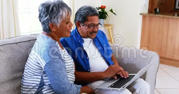高级夫妇在4k客厅使用笔记本电脑视频的预览图