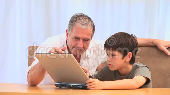 爷爷和他孙子用笔记本电脑视频的预览图
