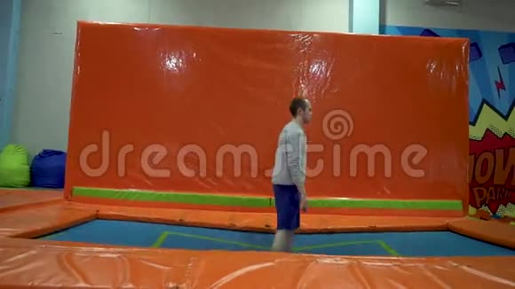 年轻人在印第安纳州的蹦床上跳活跃的人男性在体育中心有乐趣慢动作视频的预览图