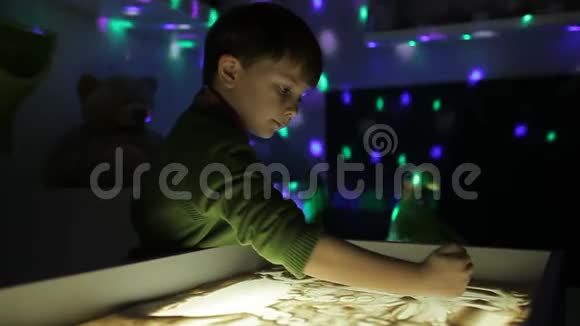 孩子们用双手在沙子上用光照画画视频的预览图