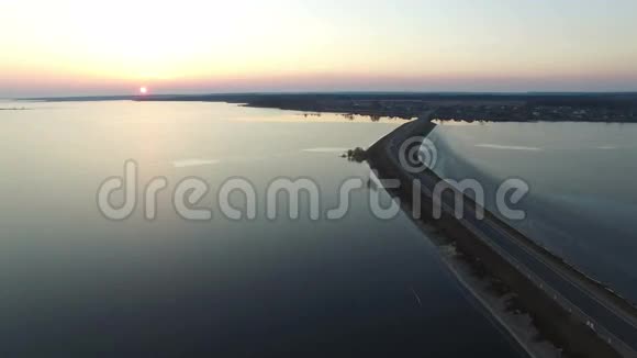 4K早春日落时分在水中飞越公路空中飞行视频的预览图