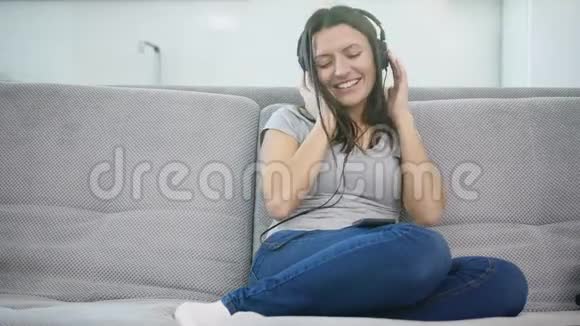 女人用耳机听音乐视频的预览图