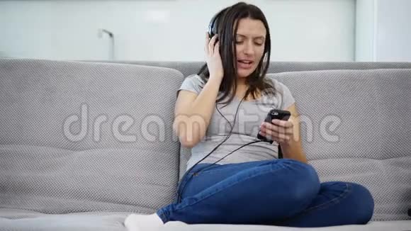 女人用耳机听音乐视频的预览图