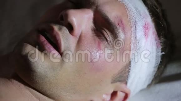 头部受伤的人躺在床上包扎好的头他脸上的瘀伤视频的预览图