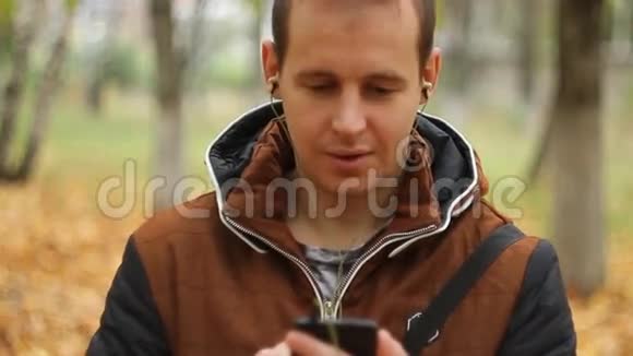 在智能手机上听音乐的年轻人视频的预览图