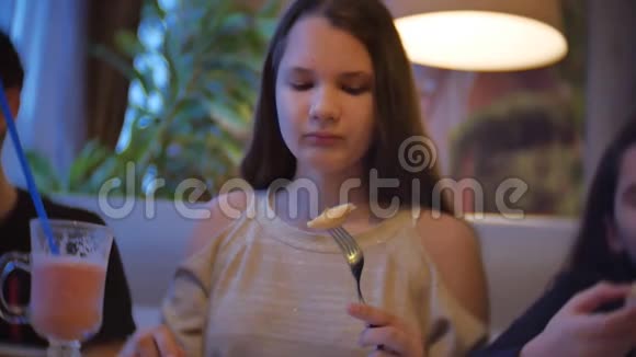 孩子们女孩一家人在咖啡馆里吃披萨青少年在咖啡厅慢动作视频中吃快餐视频的预览图