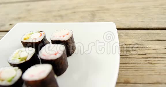 在木制背景的盘子里端上木寿司视频的预览图