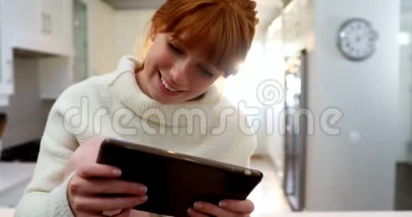 美丽的女人在喝咖啡时使用数码平板电脑视频的预览图