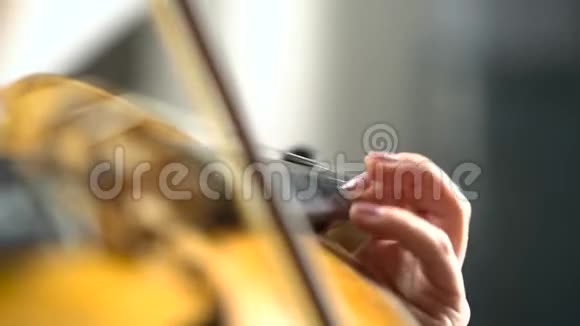 女孩用手指弹奏小提琴的琴弦关门视频的预览图