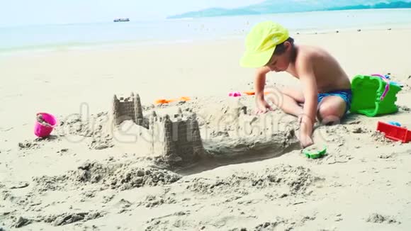 在泰国海滩上玩沙子的金发男孩视频的预览图