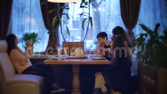 孩子们一家人在咖啡馆里吃披萨青少年在咖啡厅慢动作视频中吃快餐视频的预览图