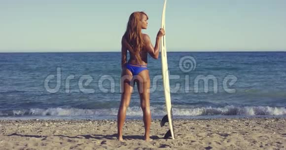 有冲浪板的女人在海滩散步视频的预览图