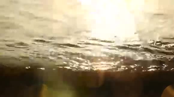 日出对土耳其海滩上的石头和沙子的反射视频的预览图