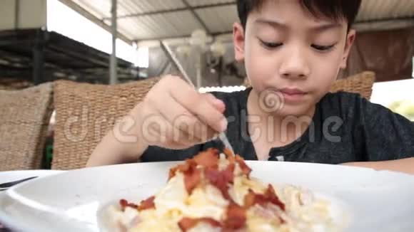 在餐馆吃意大利面的亚洲小孩视频的预览图