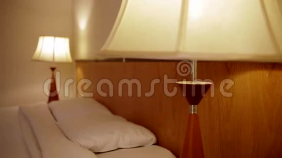 在酒店房间里有一盏灯和一张双人床视频的预览图