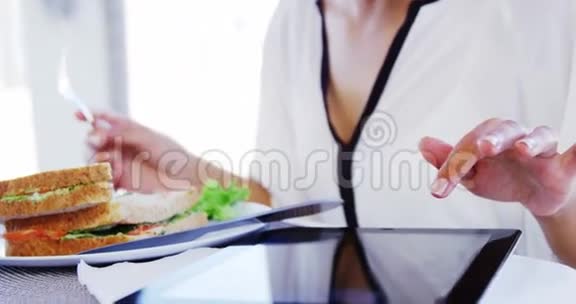 女人吃午饭用平板电脑视频的预览图