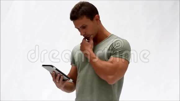 肌肉发达的年轻人用平板电脑站立视频的预览图