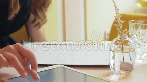 一位商务女性坐在咖啡馆的桌子旁喝着咖啡正在制作平板电脑视频的预览图