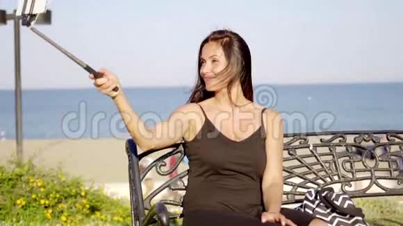 漂亮的年轻女人在手机上自拍视频的预览图