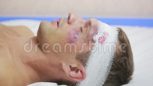 头部受伤的人躺在床上包扎好的头他脸上的瘀伤视频的预览图