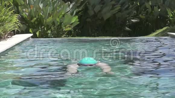 这位年轻的运动员在游泳池中轻轻地拍着相机动作缓慢视频的预览图