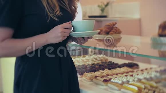 她的买家选择美味年轻迷人的女孩女人在咖啡店买糕点蛋糕蛋糕马卡龙A视频的预览图