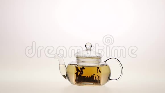 用透明玻璃茶壶冲泡叶茶白色背景视频的预览图