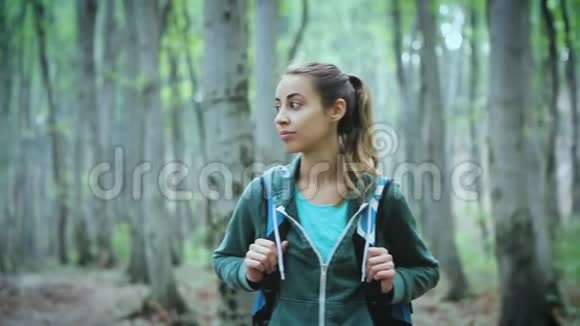 积极健康的女人在美丽的森林徒步旅行的肖像视频的预览图